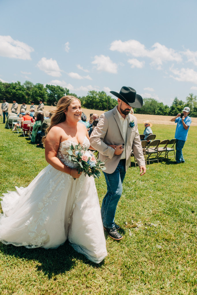 bride and groom walk down the isle with smiles as they leave the ceremony