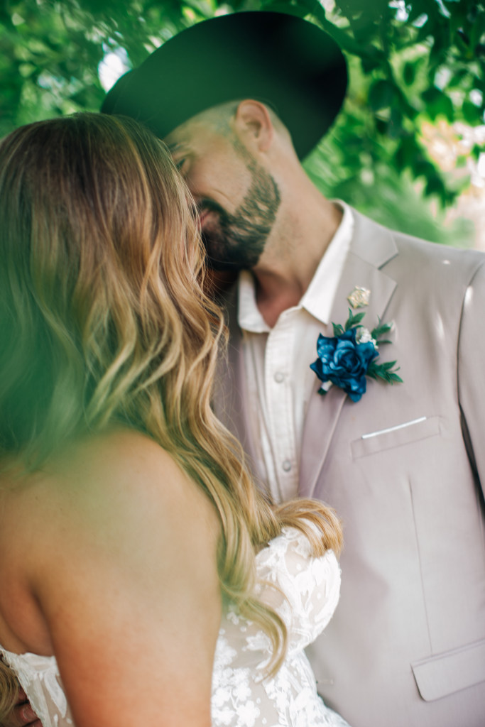 bride and groom share a moment under a tree after their wedding ceremony